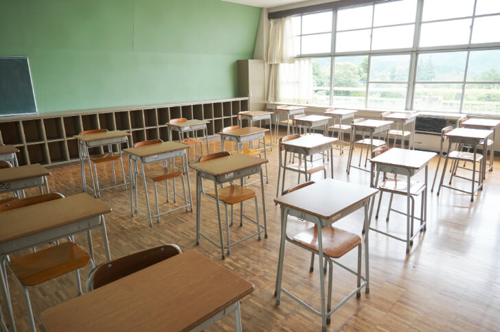 机と椅子が並ぶ学校の教室