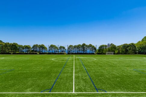 青空と人工芝のサッカーグラウンド