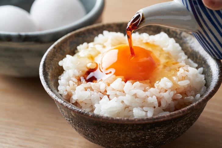 卵かけご飯に醤油をかける（出典：pixta.jp）