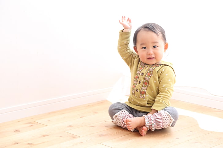 お座りする1歳の女の子（出典：pixta.jp）