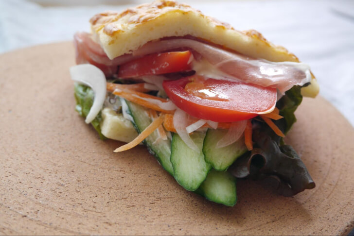 パンからはみ出るほどの生ハムと野菜