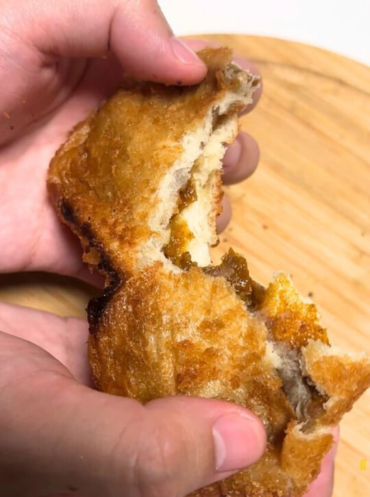 カレーパンを手でちぎる様子