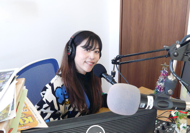 スタジオ内のマイク前で微笑む星本さん