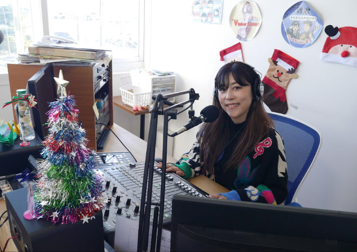 スタジオブースで微笑む星本さん