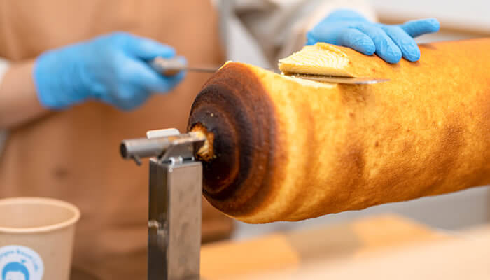 朝焼き生バウム みたらしをカットする様子(出典:金笛しょうゆ | 笛木醤油)