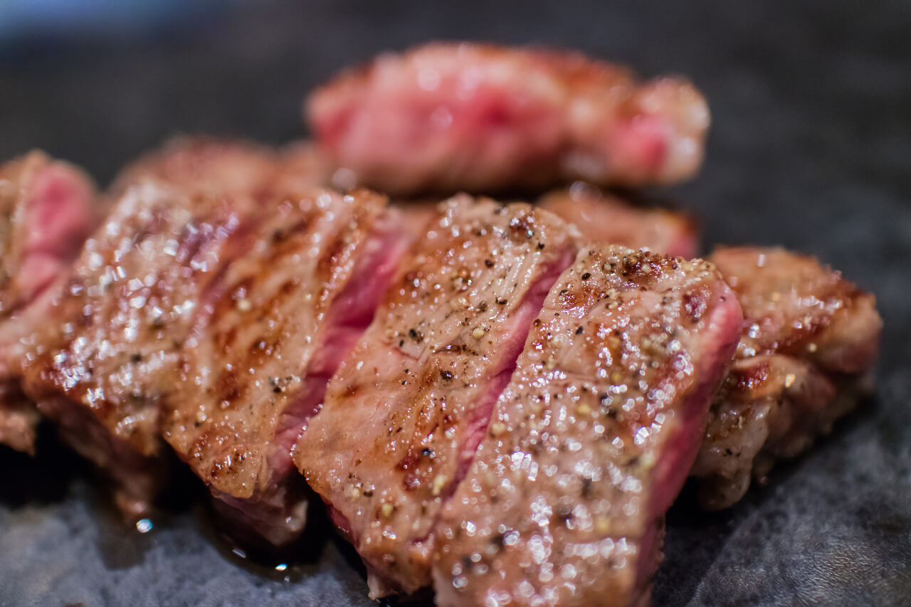 鉄板で焼かれる赤身ステーキ（出典：pixta.jp）